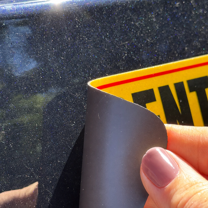 Curled corner on a vehicle magnetic sign caused by heat and improper storage