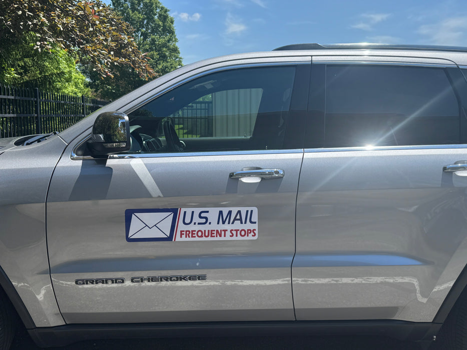 Silver SUV with a U.S. Mail frequent stops magnet on the side.