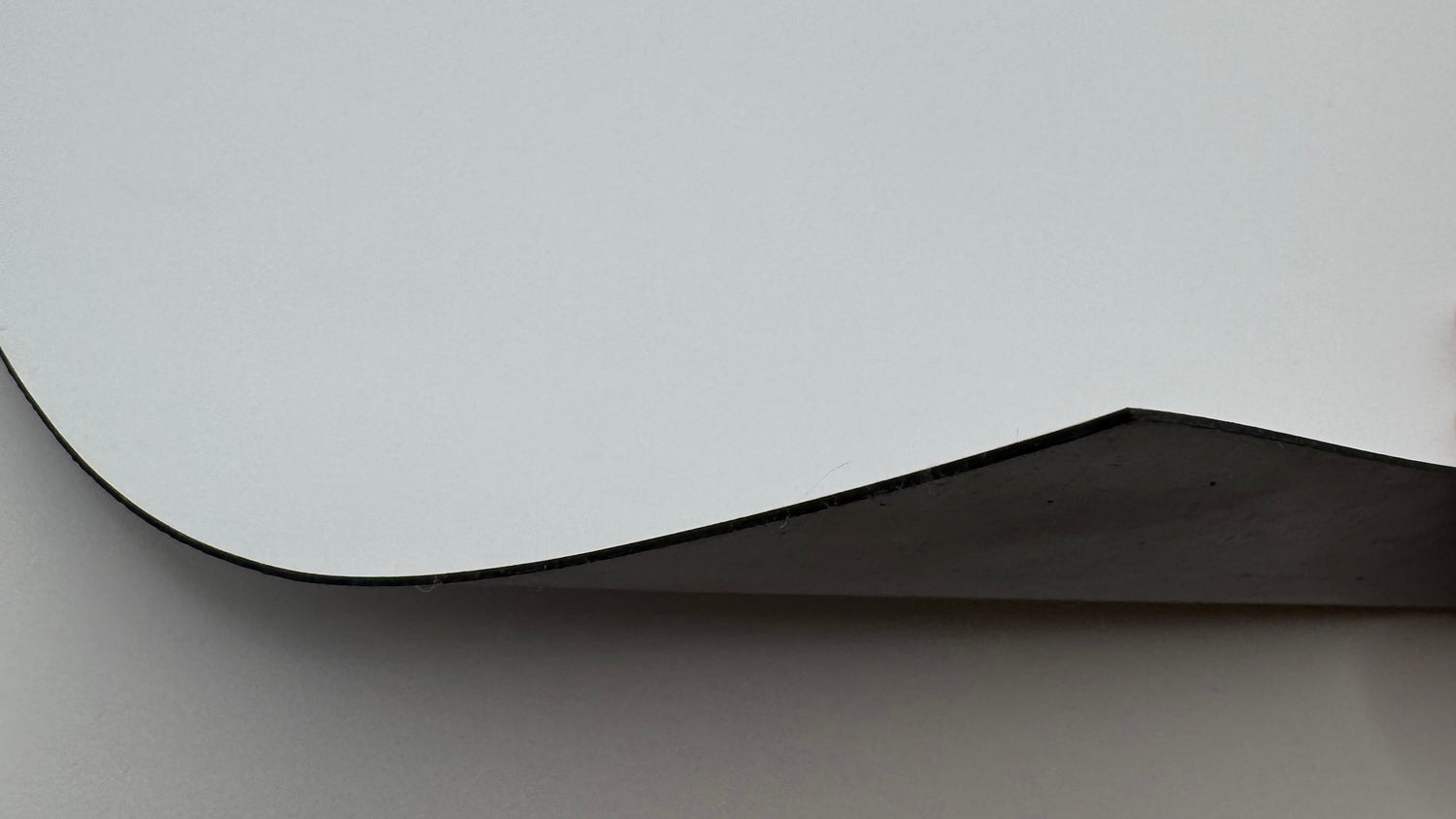 Flexible blank magnetic sheet showing white face and magnetic backing