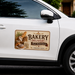 White car with a bakery delivery sign on the side