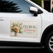 White car with a floral delivery magnetic sign on the side