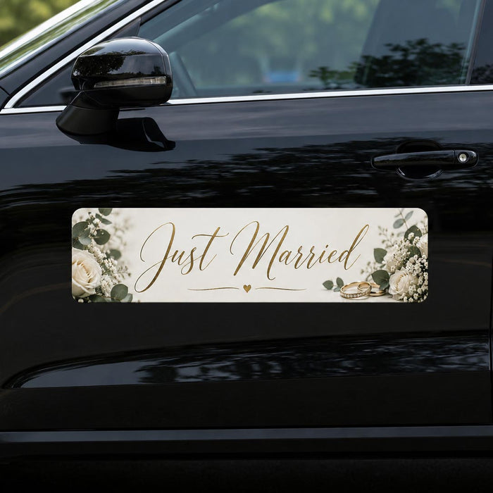 Car with a 'Just Married' decorative car banner featuring flowers and rings on a black car.