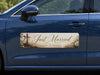 Car door with 'Just Married' sticker featuring crosses and flowers