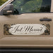 Beige vehicle with 'Just Married' decal on a nature-themed background