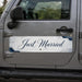 Car door with 'Just Married' sticker on a vehicle outdoors