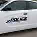 White police car with 'POLICE' decal on a gray surface