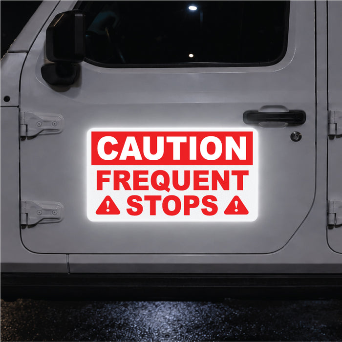 White vehicle with a reflective red and white caution frequent stops magnetic sign on the door.