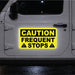 Yellow caution sign on a vehicle door indicating 'Frequent Stops' at night.